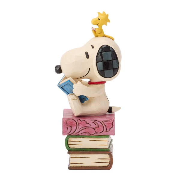 Snoopy lit des livres empilés - Peanuts